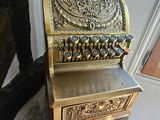 an old fashioned cash register sitting on a wooden floor
