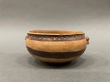 an old brown and black pot sitting on top of a table