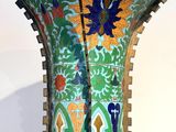 a vase that is sitting on a stand on a table