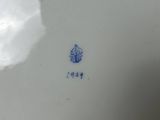 a white plate with a blue flower on it