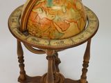 a small globe sitting on a stand on a white surface