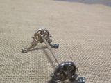 a small silver skull and crossbone on a pillow