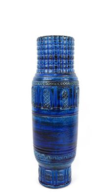 a blue vase that is sitting on a white surface
