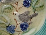 une assiette sur laquelle est peint un oiseau, posée sur une table