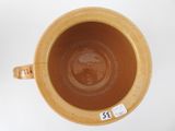 a brown cup with a handle on a white table