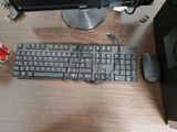 a keyboard and a mouse on a desk with a monitor