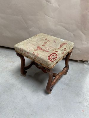 un petit tabouret en bois avec une assise rembourrée à motifs floraux