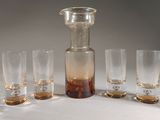 six verres et une carafe sur la table