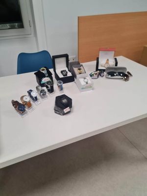 une table blanche sur laquelle sont posés plusieurs montres et d'autres objets