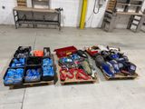 Plusieurs caisses d'outils sont alignées sur des palettes dans un entrepôt