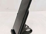 a close up of a cell phone on a stand on a white surface