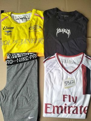 trois t-shirts et pantalons de survêtement Nike pour homme, disposés sur une boîte en carton