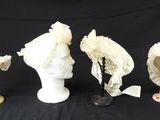 trois chapeaux et un porte-chapeaux sur fond noir