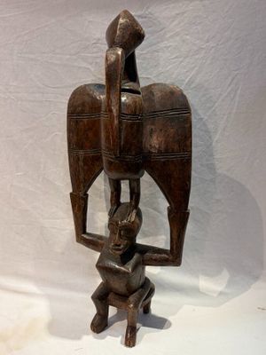 statue d'un homme tenant un oiseau sur son dos