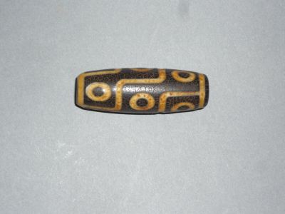 un gros plan d'une perle marron et noire sur une surface blanche