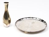 un plateau en argent et un vase en argent posés sur une table blanche