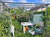 une petite terrasse avec une table et des chaises dans le jardin