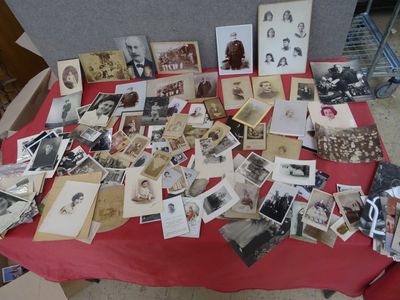une table recouverte d'une nappe rouge sur laquelle sont posées de vieilles photos