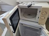 a microwave that is sitting inside of a small refrigerator