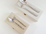 two spoons and a fork in a box on a table