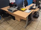 un bureau sur lequel sont posés un ordinateur portable et un écran, dans une pièce