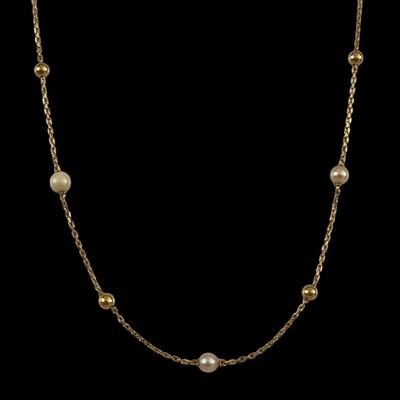 un collier en or orné de perles sur fond noir