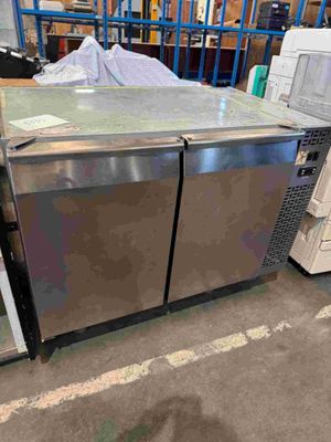 stainless steel double door refrigerators in a warehouse with boxes and other items