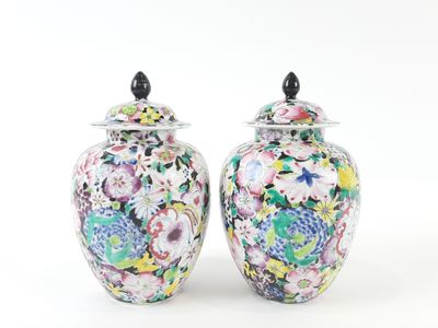 pair of colorful vases sitting on a white surface with a white background