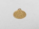 a gold coin with a woman on it sitting on a white surface