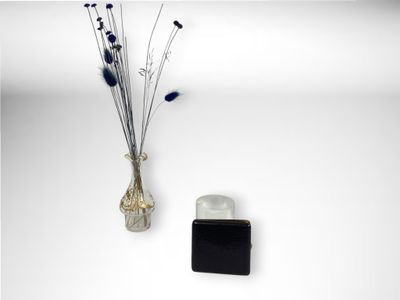 un vase contenant des fleurs, à côté d'une bouteille d'eau