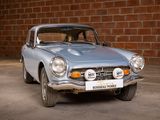 a silver car that is parked in front of a brick wall