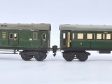 quatre petits trains miniatures alignés sur une surface blanche
