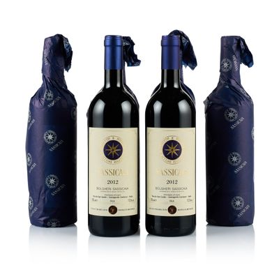 trois bouteilles de vin sont posées les unes à côté des autres sur une surface blanche