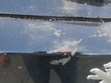 a reflection of a person standing in the reflection of a car