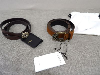 two belts and a wallet on a bed