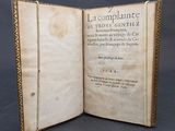 an old book opened to reveal a page of text on a black background