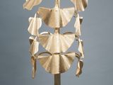 an image of a gold sculpture of leaves on a white pedestal
