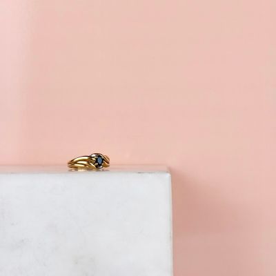an image of a gold ring sitting on top of a marble block