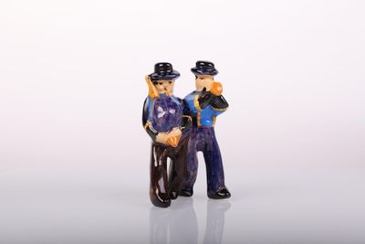 deux figurines d'un homme et d'une femme debout l'un à côté de l'autre