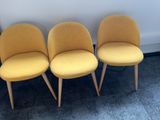 three yellow chairs sitting next to each other on a carpeted floor