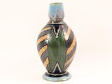 a vase that has a green and yellow design on it
