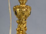 an image of a gold colored lamp on a table with a cord