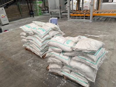 sacs de ciment sur des palettes dans un entrepôt