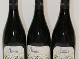 trois bouteilles de vin sont alignées sur une table
