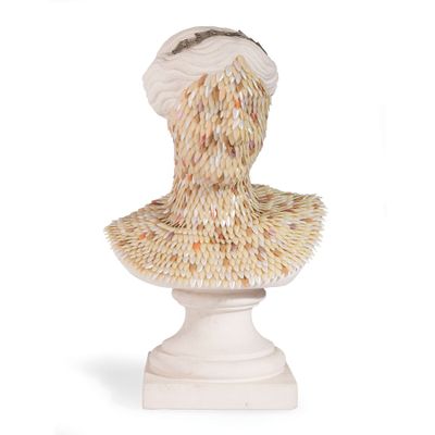 une sculpture représentant la tête d'une femme posée sur un socle blanc