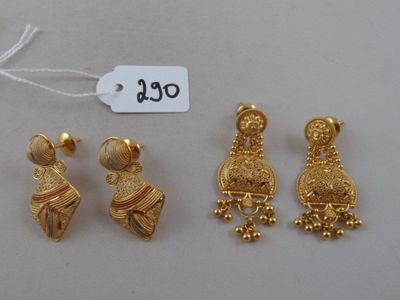 three pairs of gold earrings and a necklace with a price tag