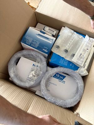 someone is opening a cardboard box with a bunch of electronics inside of it