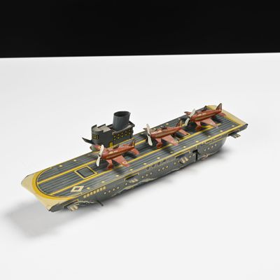 une maquette de bateau posée sur une surface blanche