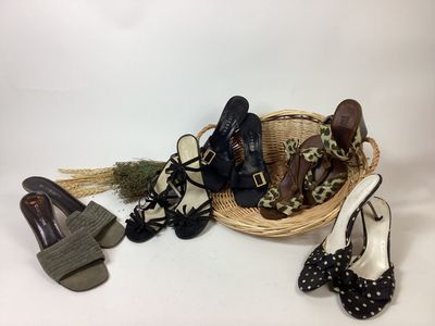 several pairs of women ' s shoes in a wicker basket on a white background