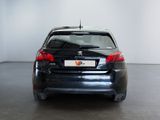 a black car parked in a room with a white wall